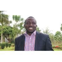 Segan Fatumo. Credit: Segun Fatumo Headshot of Segun Fatumo. Segan is wearing a checked shirt and a black jacket. He is standing outside, surrounded by trees.