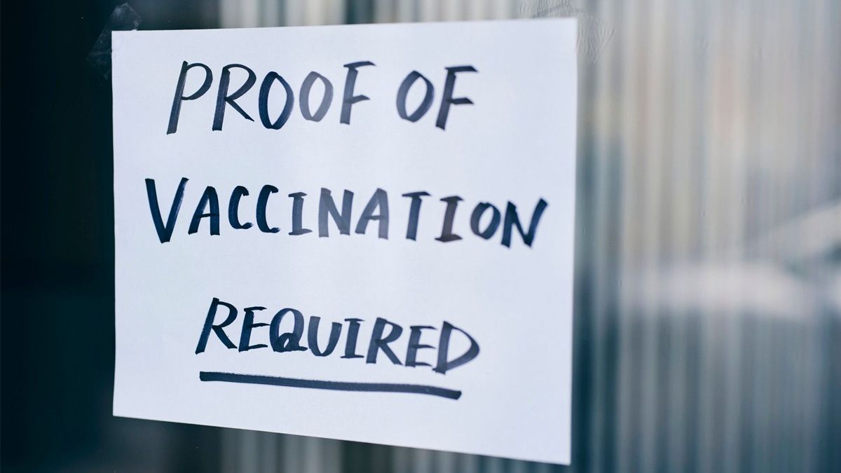 A sign in a window stating "Proof of vaccination required"