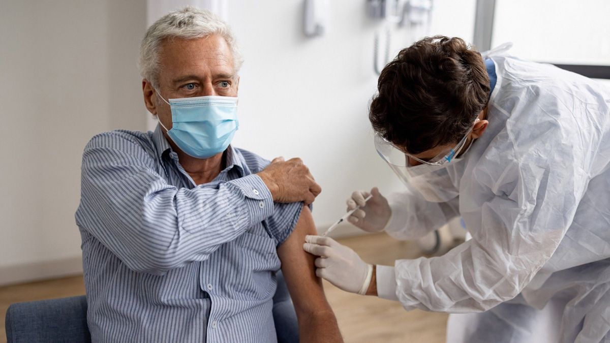 Common IM sites include the deltoid muscle in adults and the vastus lateralis muscle in young children and SC sites include the outer aspect of the upper arm in adults or the anterolateral thigh in young children. An older man in a face mask receiving a vaccine in their upper arm from a doctor.