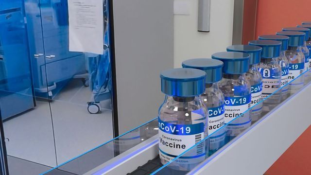 A row of vials containing COVID-19 vaccine in a vaccine manufacturing site. 