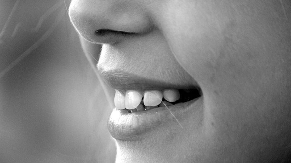 Close up of a lady smiling and showing her teeth.