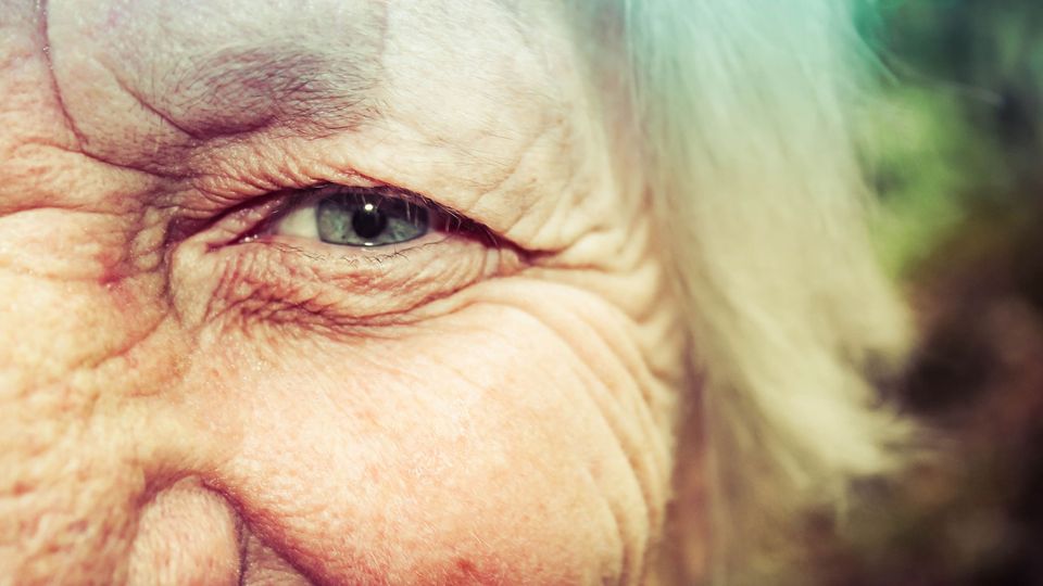 A close up picture of an old person's eye.