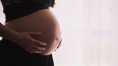 A woman touching her baby bump.