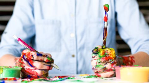 A person holding a painbrush covered in paint.