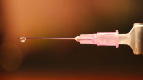 A drop of liquid at the end of a syringe.