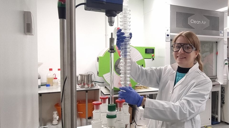 A scientist stands next to the DrySyn heating block and CondenSyn Maxi waterless condenser.