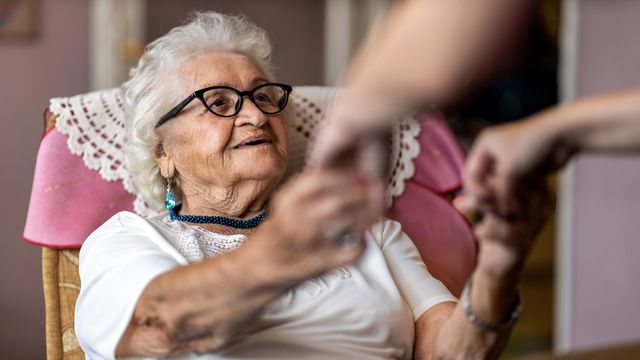 An older woman sitting in a chair. 