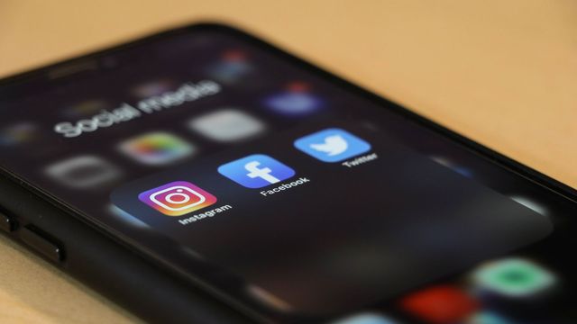 A phone showing apps for Instagram, Facebook and Twitter. 