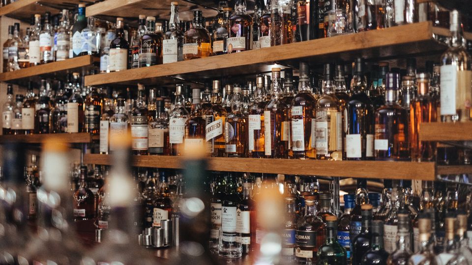 A fully stocked bar with lots of alcohol bottles.