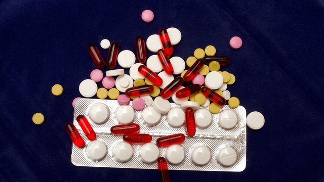 White pills in a packet, with red, white and pink pills on top. 