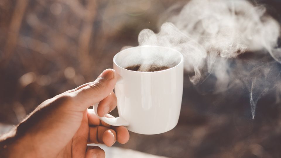 A cup of steaming hot coffee.