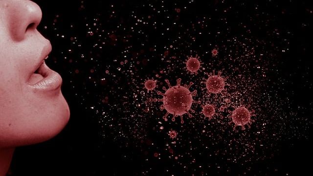 Person sneezing and stylized representation of a cloud of influenza virus particles shooting out into the air. 