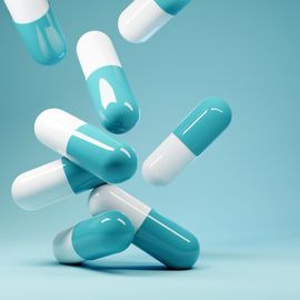 绿色和白色的药丸落在地上。