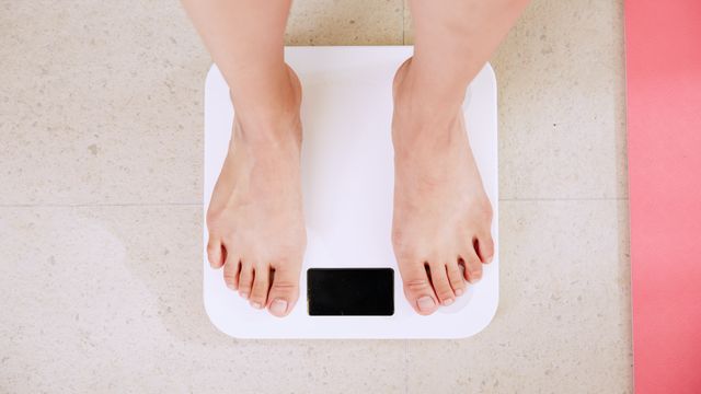 A person standing on weighing scales.  