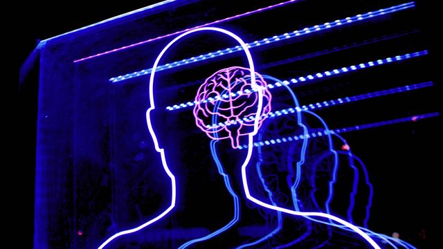 Neon lights showing the outline of a person and a brain. 