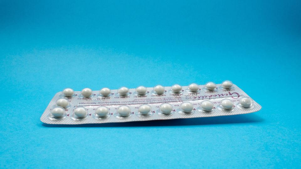 A packet of contraceptive pills on a blue background.