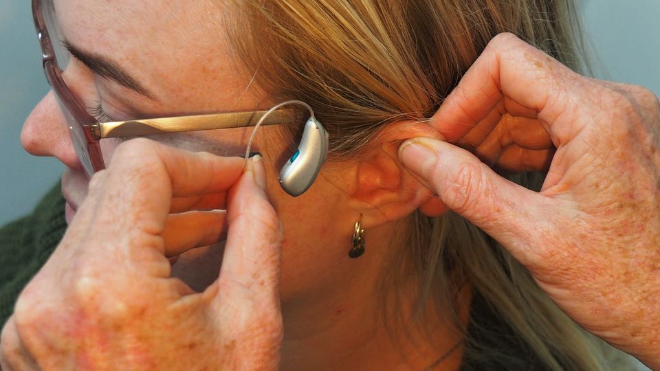 A person having a hear aid fitted.