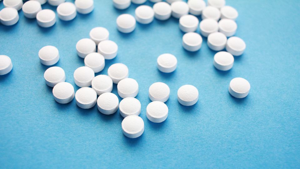 White circular pills on a blue background.