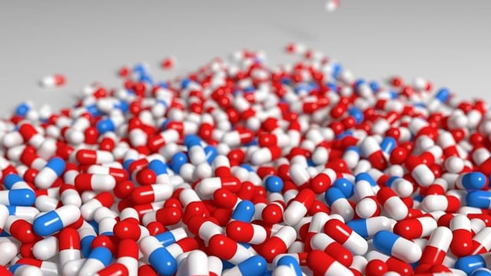 Pile of red, white and blue capsule medicinal drugs. 