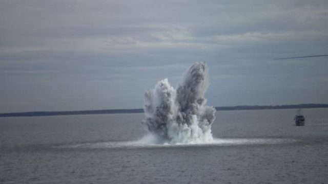 An explosion underwater produces a large disturbance of water at the surface.