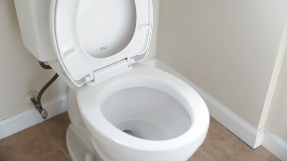 A clean, white toilet with the lid up.