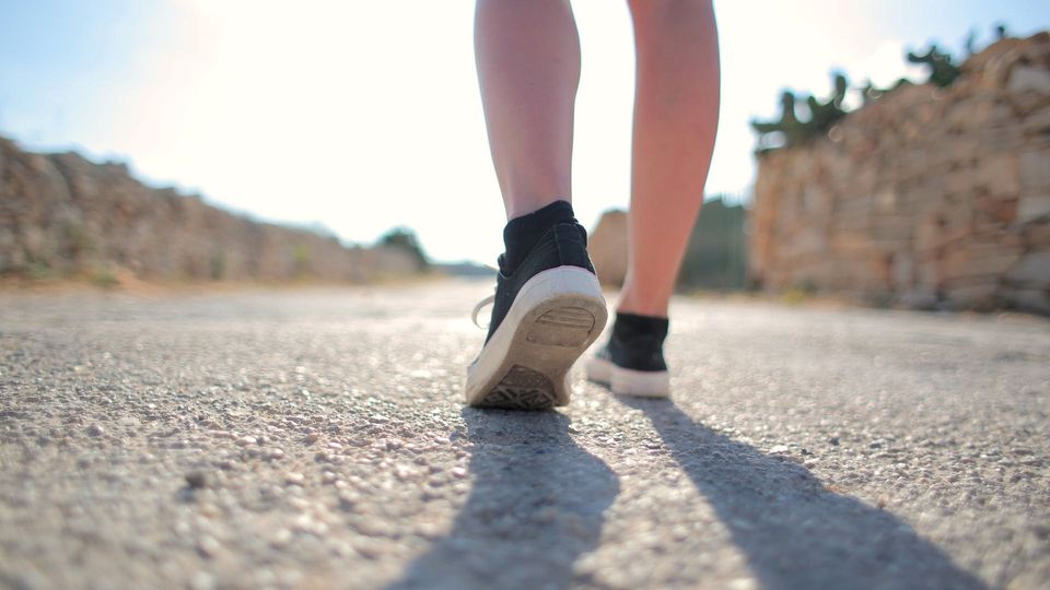 Close up of a persons lower legs and feet while walking