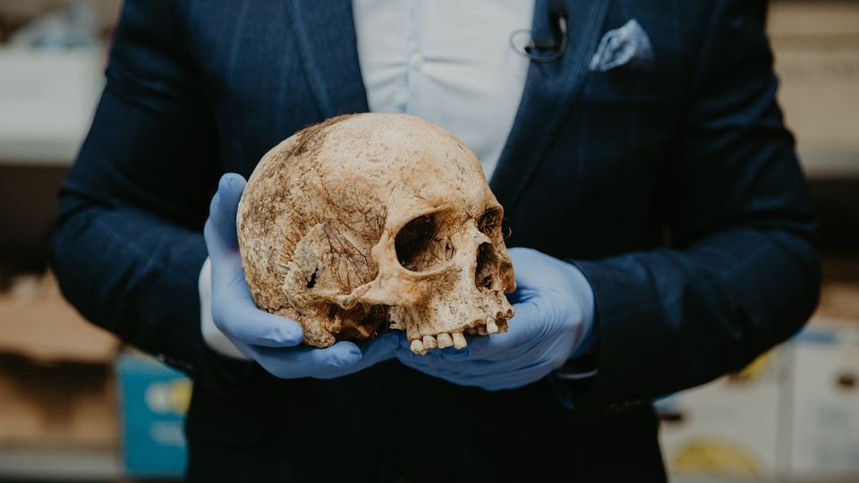 An individual holding a skull.