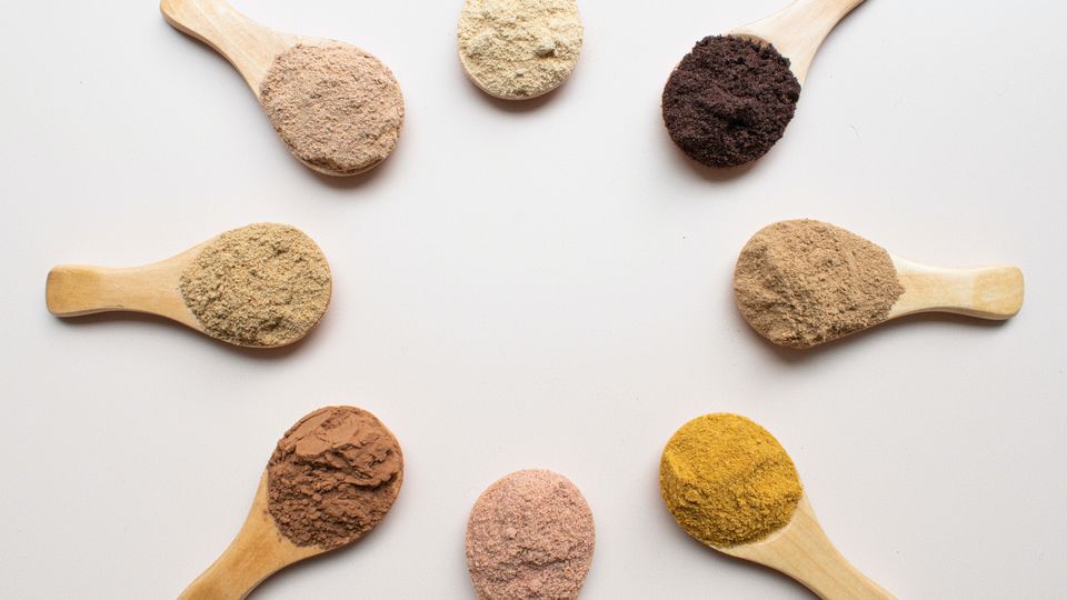 Wooden spoons containing powders of different colors.