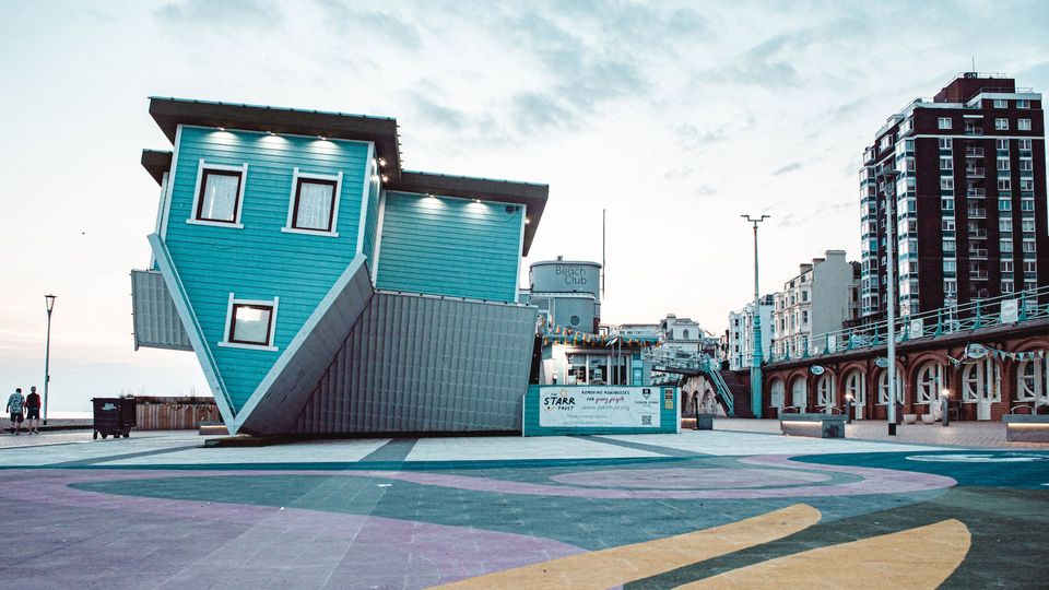 An upside down house on a street.