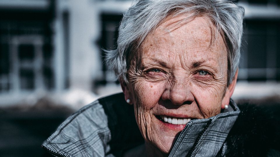 A woman smiling with wrinkles.