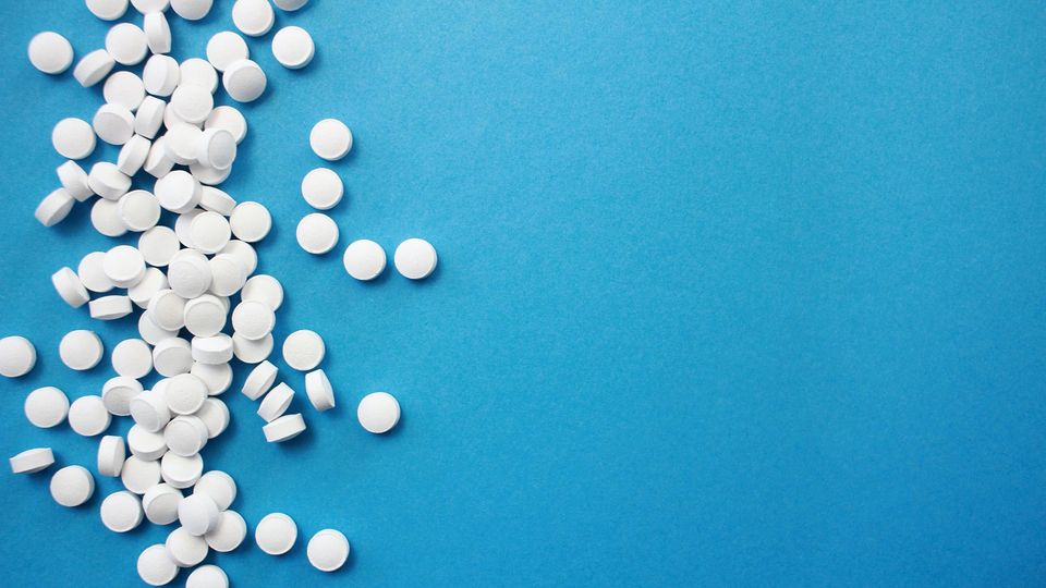 White pills on a blue background.