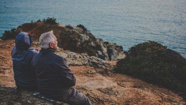 Old couple looking out at the sea.