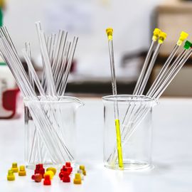 Two glass beakers holding NMR glass tubes. 