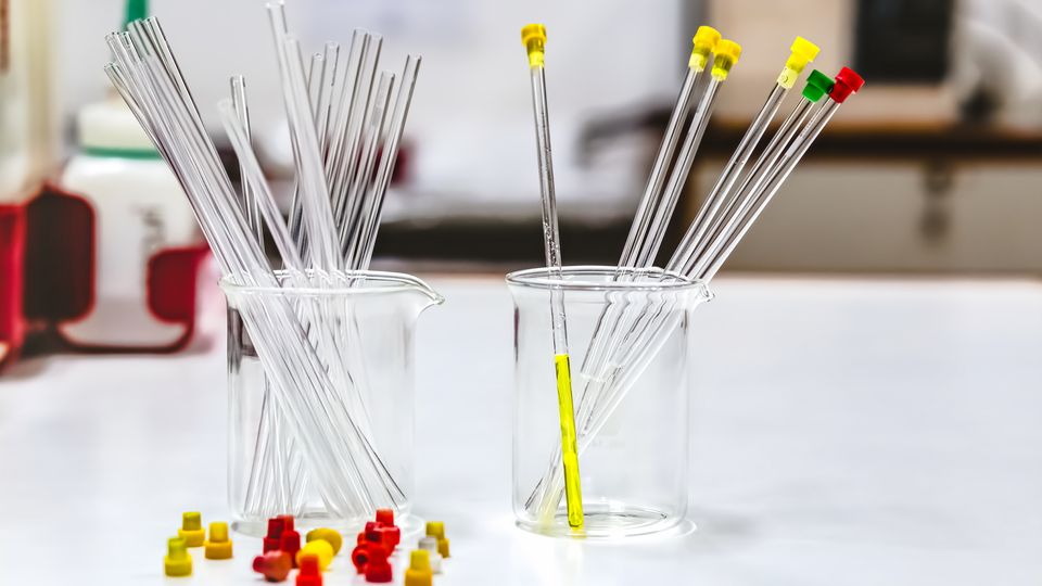 Two glass beakers holding NMR glass tubes.