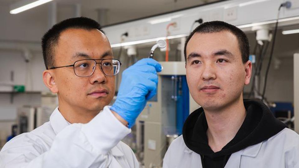 Researchers holding the water battery.