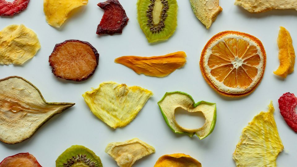 Slices of different dried fruits on a white background.