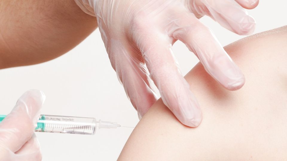 Doctor administering a vaccination into a patients arm