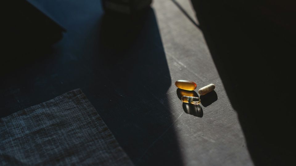 Three different supplement capsules on a table.