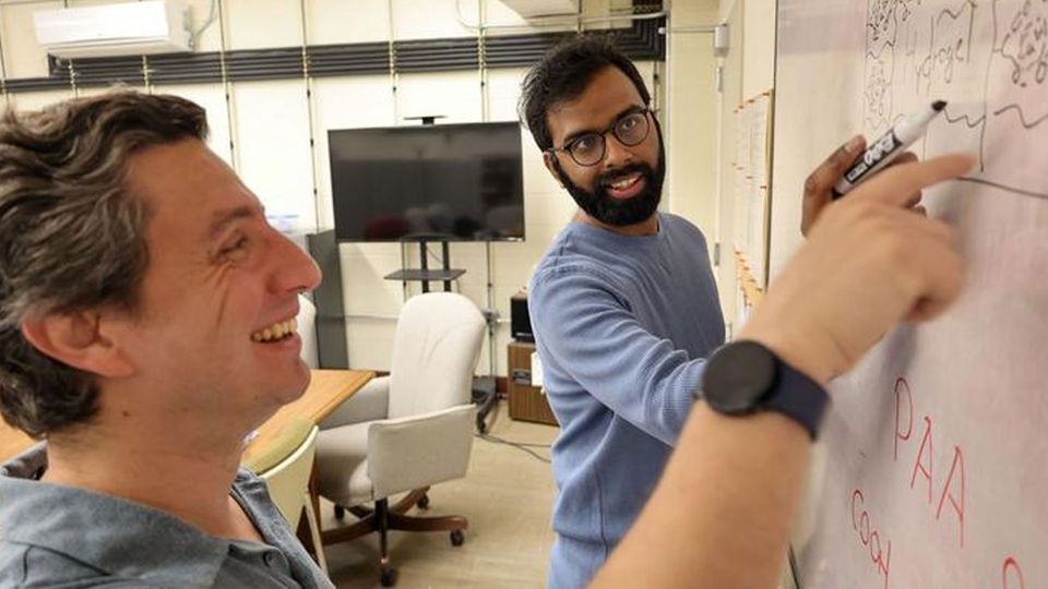Two researchers at a whiteboard.