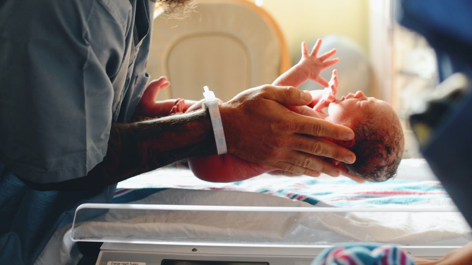 Someone holding a new born baby in their hands.