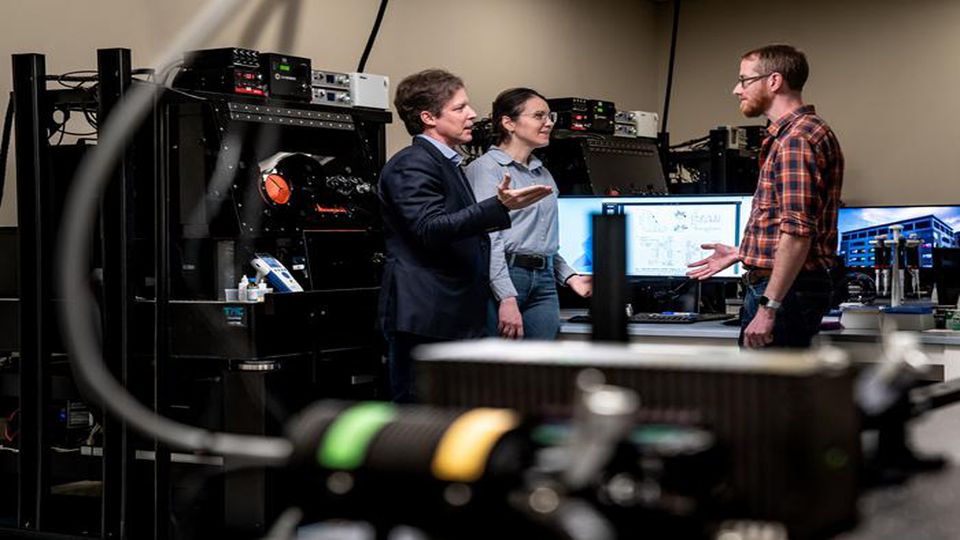 Three researchers standing in a lab.