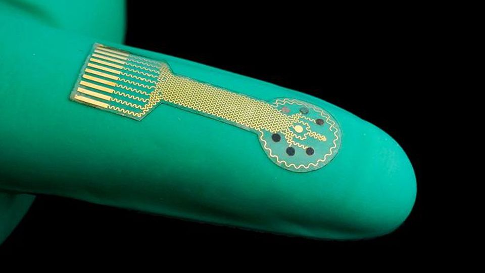 A thin electronic sensor on a gloved finger.