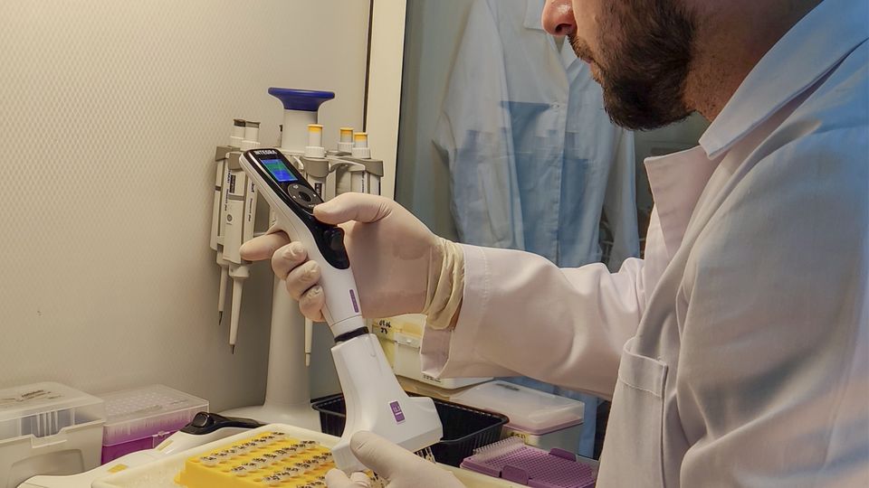 A scientist using an electronic pipette