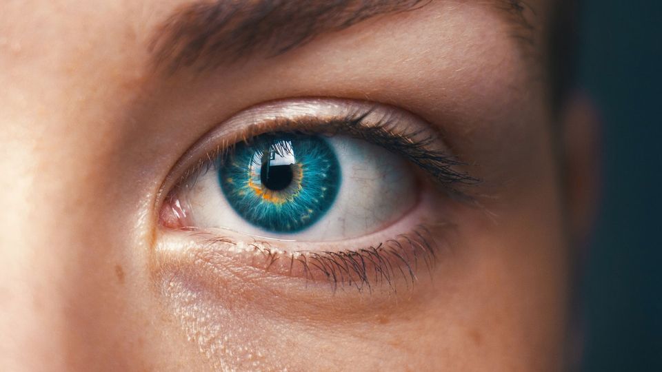 A person's blue eye looks towards the camera.