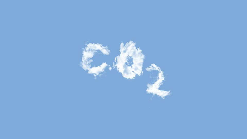 White clouds form the chemical symbol of carbon dioxide against a blue sky.