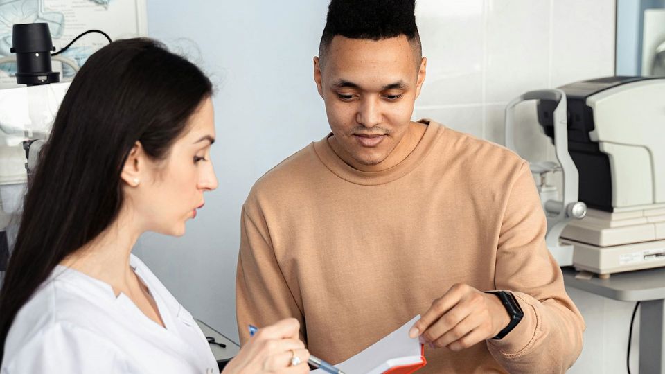 A doctor speaks to a male patient.