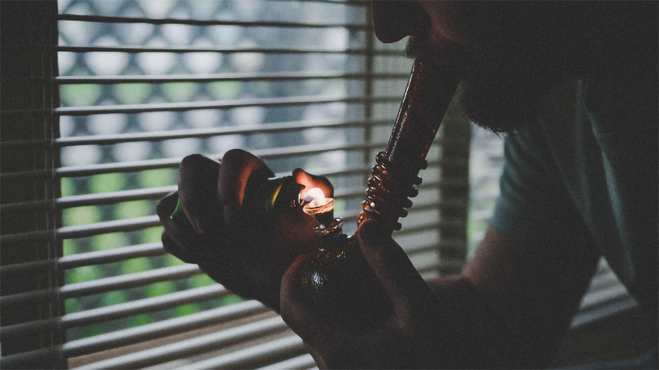 A man smokes marijuana from a bong.