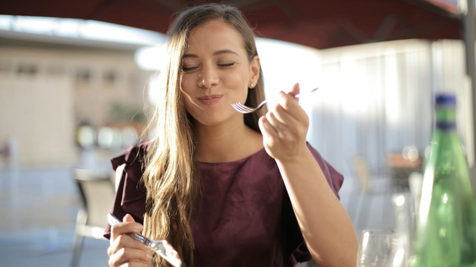 A woman enjoying a bite of food.