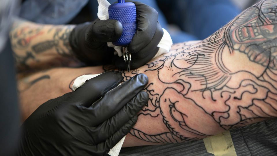 Someone tattooing a person's arm.
