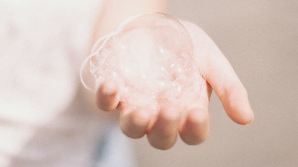 A hand outstretched with bubbles on the palm.